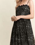 Front view of black floral scalloped tiered maxi dress with flowy silhouette