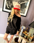 Woman wearing the Black French Terry Lounge Short Set featuring a relaxed boat neck sweatshirt, matching shorts with pockets, and soft French terry fabric.