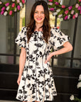 Woman wearing floral fit and flare puff sleeve mini dress from Halemi & Co.