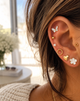 Gold and white nine-pair stud earring set featuring butterflies, hearts, flowers, stars, pearls, textured circles, and gold ball studs.