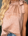 Close-up of blush leopard jacquard blouse with feminine tie neck detail