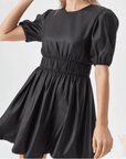 Woman wearing black bubble hem mini dress with puff sleeves