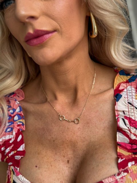Dainty snaffle bit necklace with an equestrian-inspired pendant, available in gold or silver.