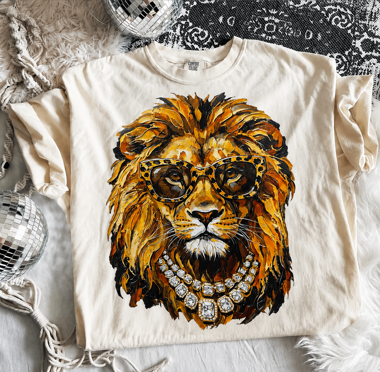 Ivory Comfort Colors graphic tee featuring a stylish lion wearing leopard print glasses and a sparkling rhinestone necklace.