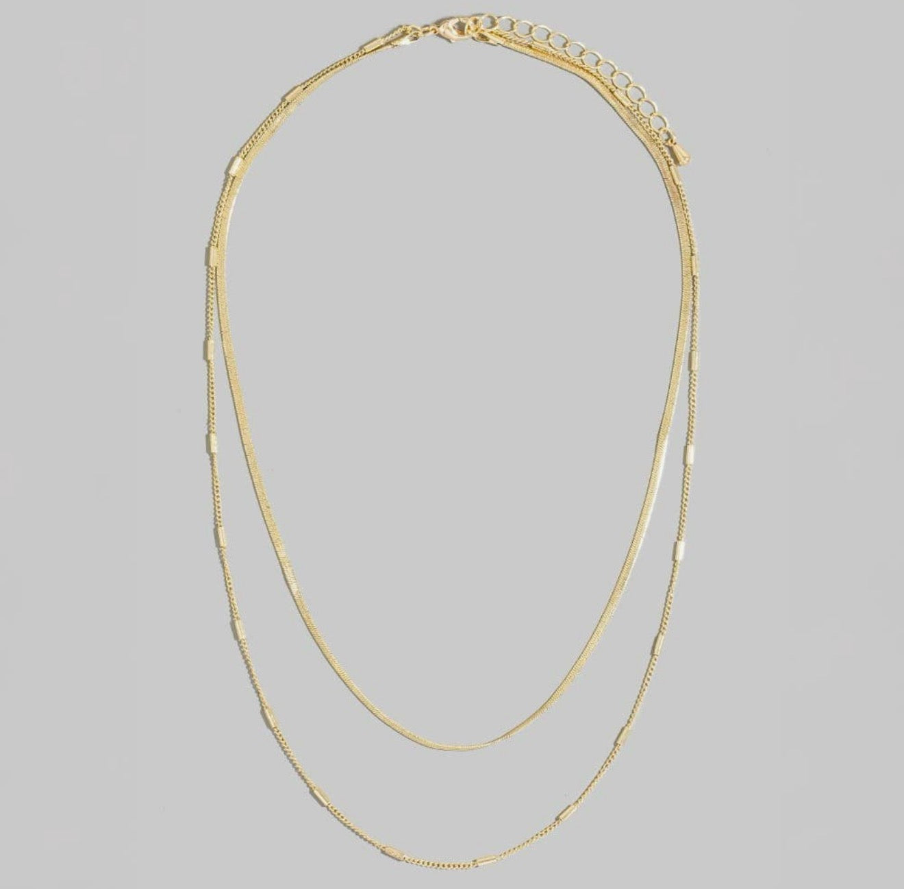 Double-layer gold necklace featuring two delicate chains with adjustable extender and polished gold finish.