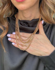 Golden Luxe layered necklace set with four gold-tone curb and paperclip chains and coordinating metallic stud earrings.