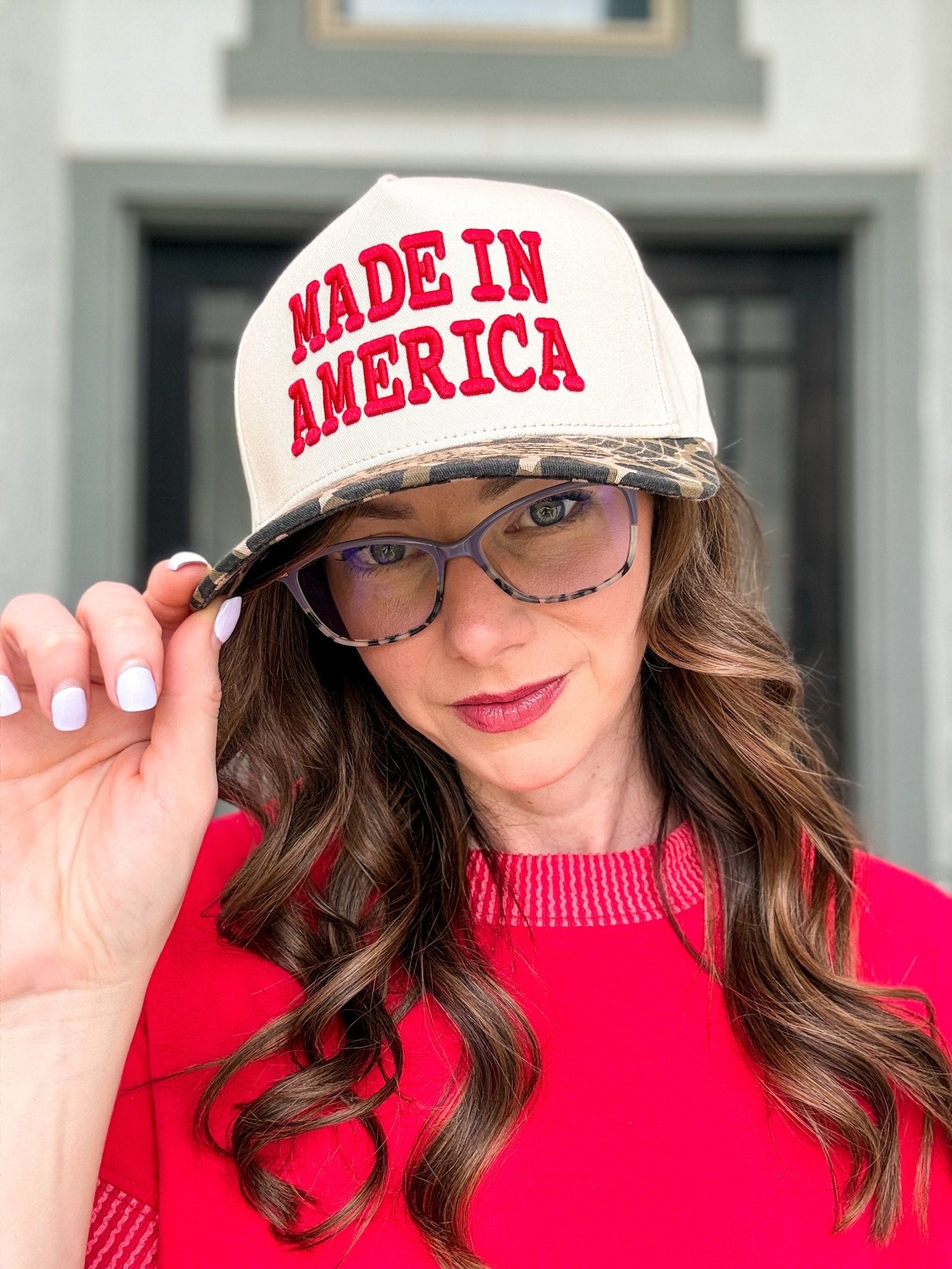 Woman wearing the Made in America trucker hat with embroidered front design and adjustable snapback closure.