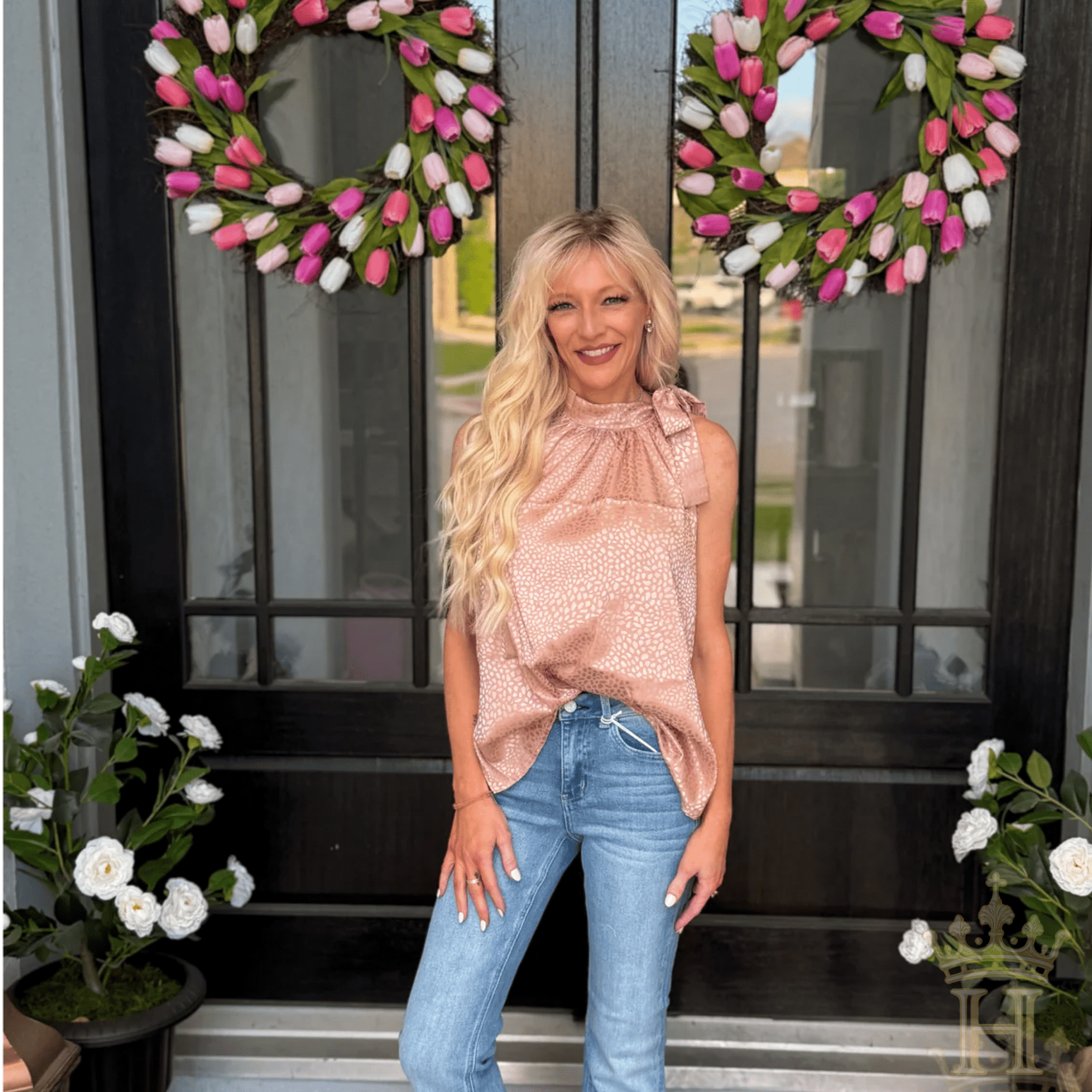 Woman wearing blush leopard jacquard tie neck blouse with denim jeans
