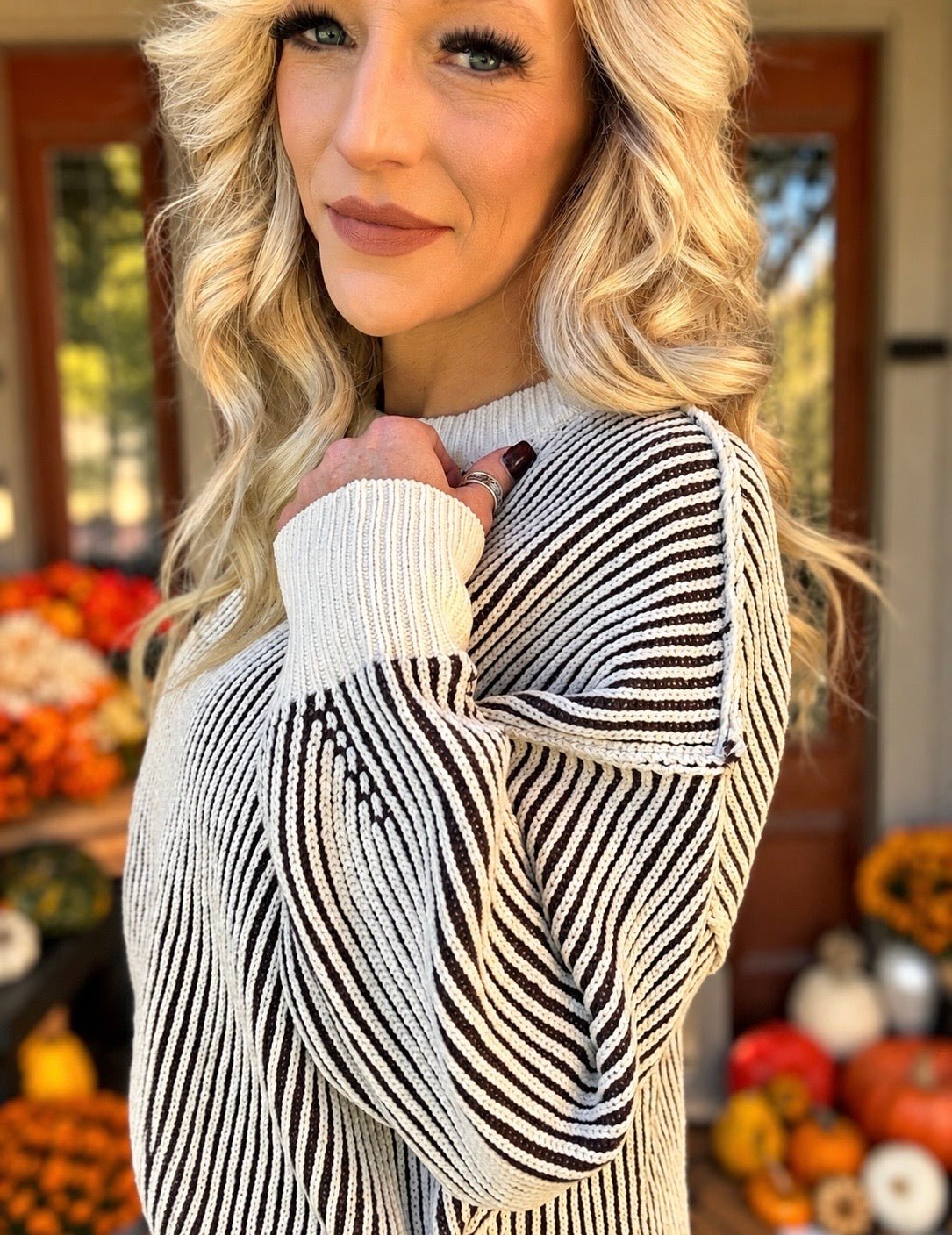 Blonde model showing detail of two tone sweater. 
