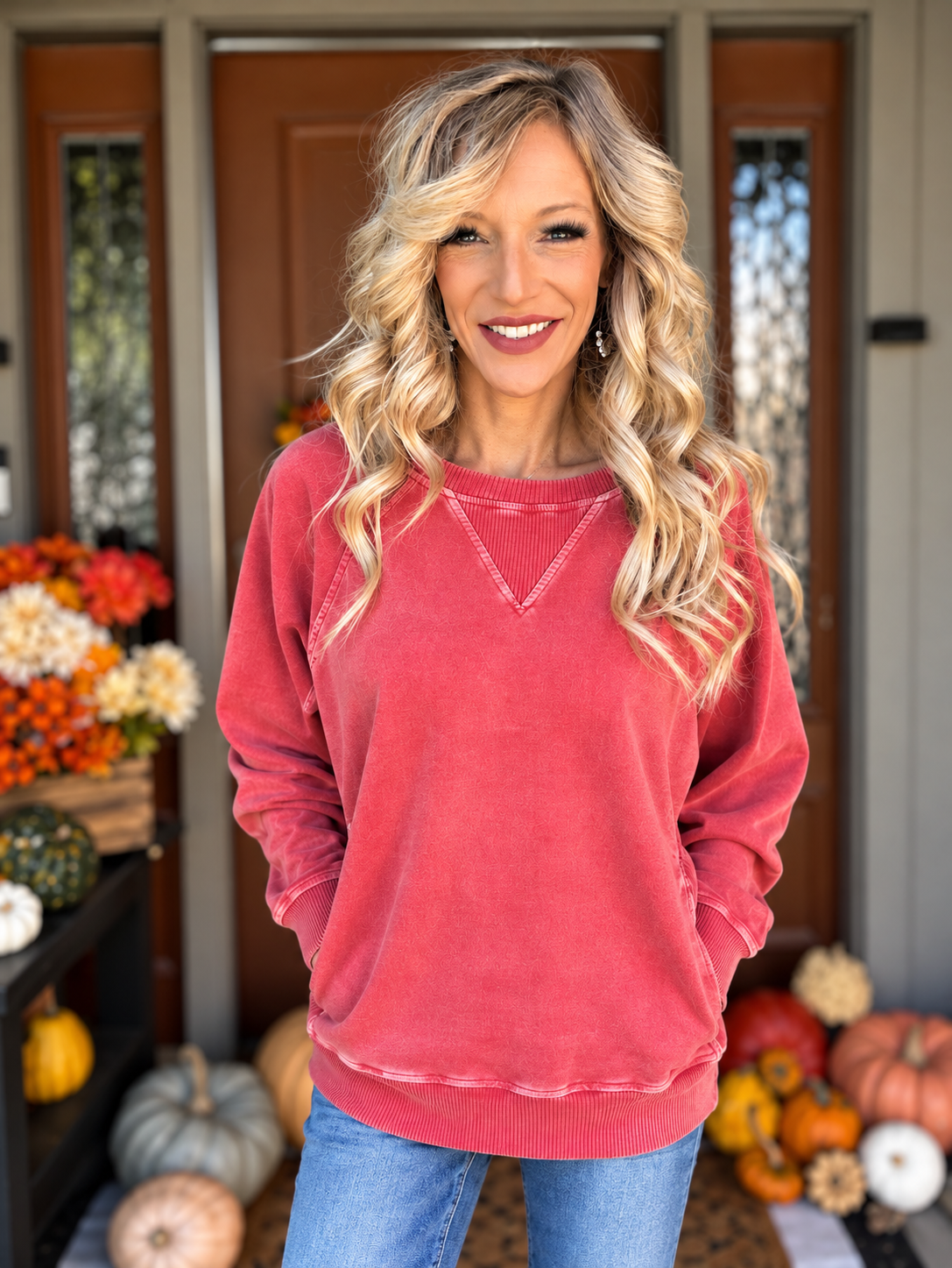 Woman wearing a washed dark red French terry pullover with ribbed V-inset neckline and side pockets, styled with blue jeans.