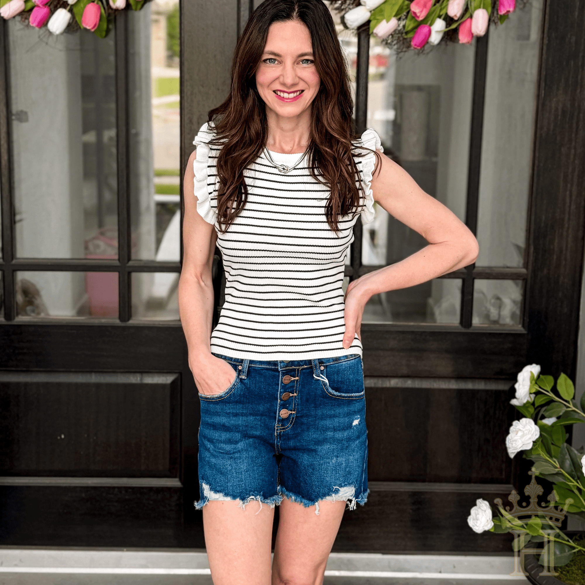 Woman wearing Risen mid rise button fly denim shorts from Halemi & Co.