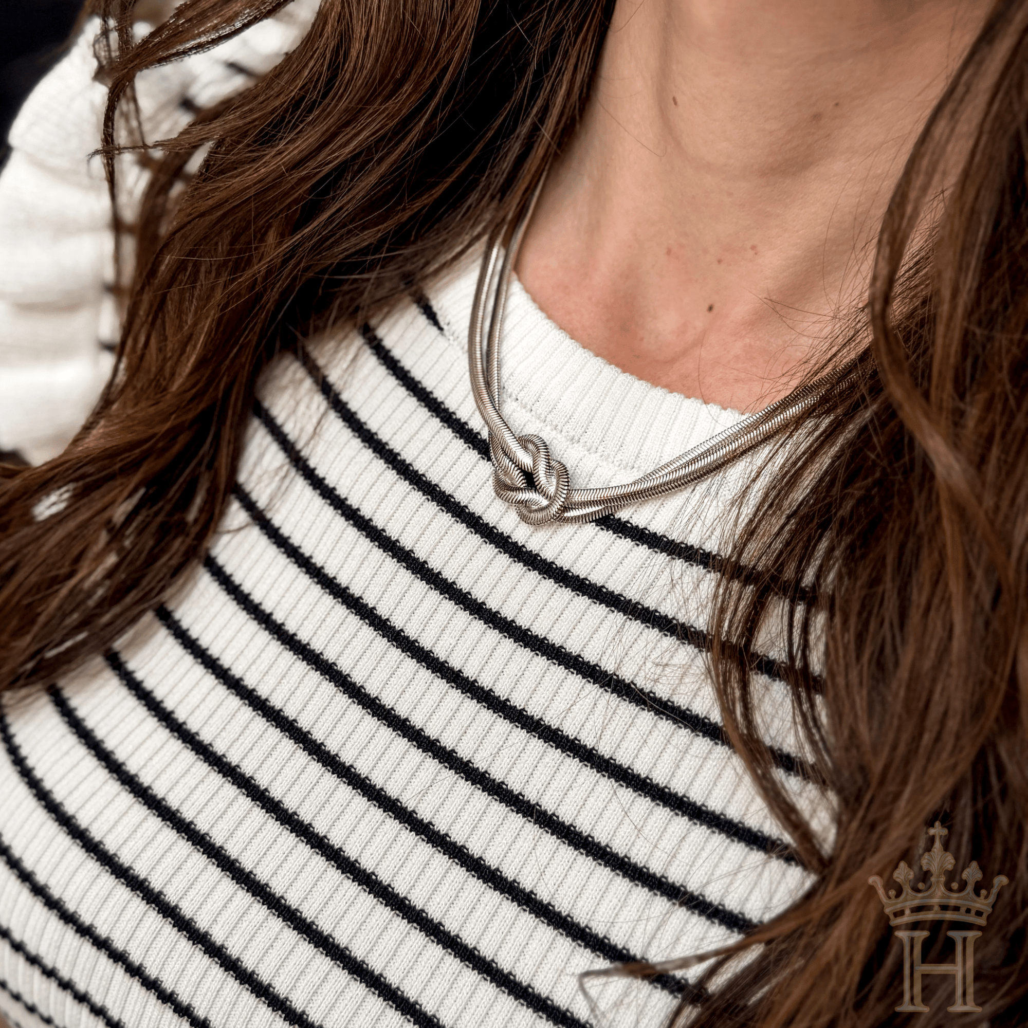 Silver-tone necklace featuring a minimalist knot design symbolizing connection and togetherness.