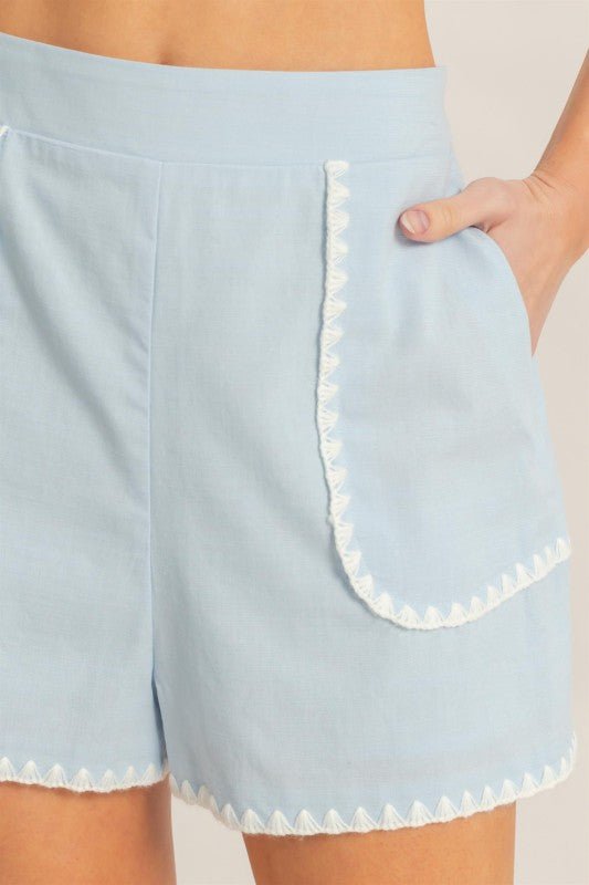 Close-up of scallop trim detailing on sky blue boutique shorts