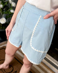Front view of sky blue high-waisted shorts with scallop trim pockets