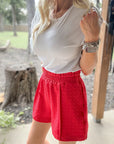 Woman wearing Smocked High-Waist Textured Shorts featuring a stretchy smocked waistband, lightweight textured fabric, and a relaxed high-rise fit.