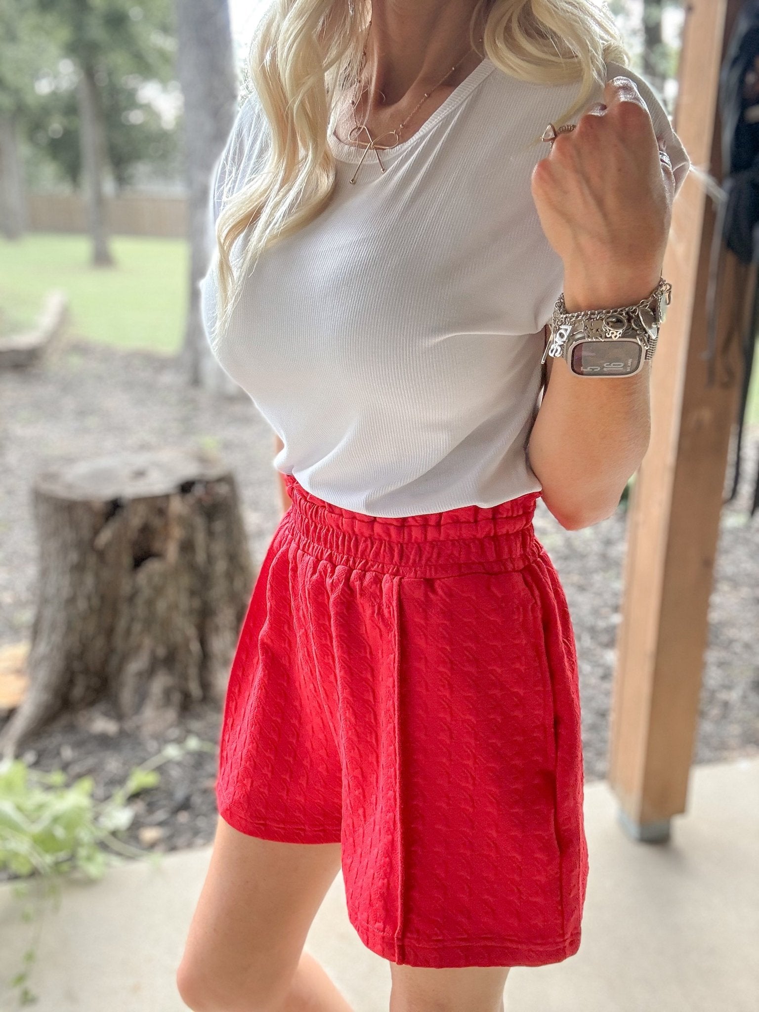 Woman wearing Smocked High-Waist Textured Shorts featuring a stretchy smocked waistband, lightweight textured fabric, and a relaxed high-rise fit.