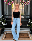 Woman wearing Vervet by Flying Monkey Optimistic Wide Leg Jeans featuring a high-rise waist, light wash denim, and a flattering wide-leg silhouette.