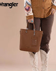 Woman carrying Wrangler brown convertible tote bag by the top handles